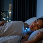 A woman sleeps peacefully in a dark bedroom while wearing a futuristic neckband device that emits a soft blue glow. City lights are visible through the window in the background.